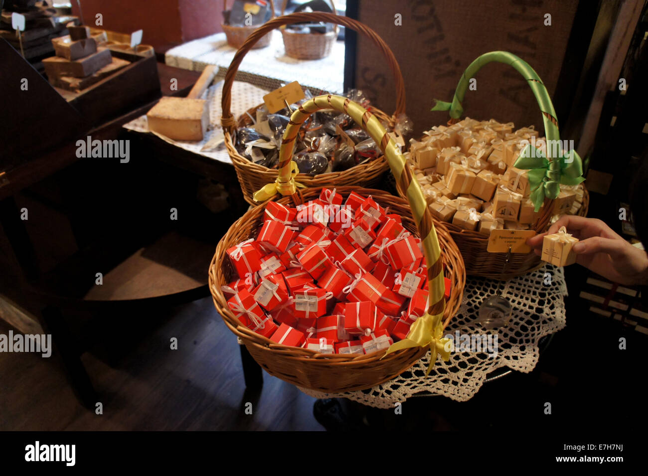Wicker basket with differently colored gift-wrapped candy bars in a chocolate shop in Lviv Stock Photo