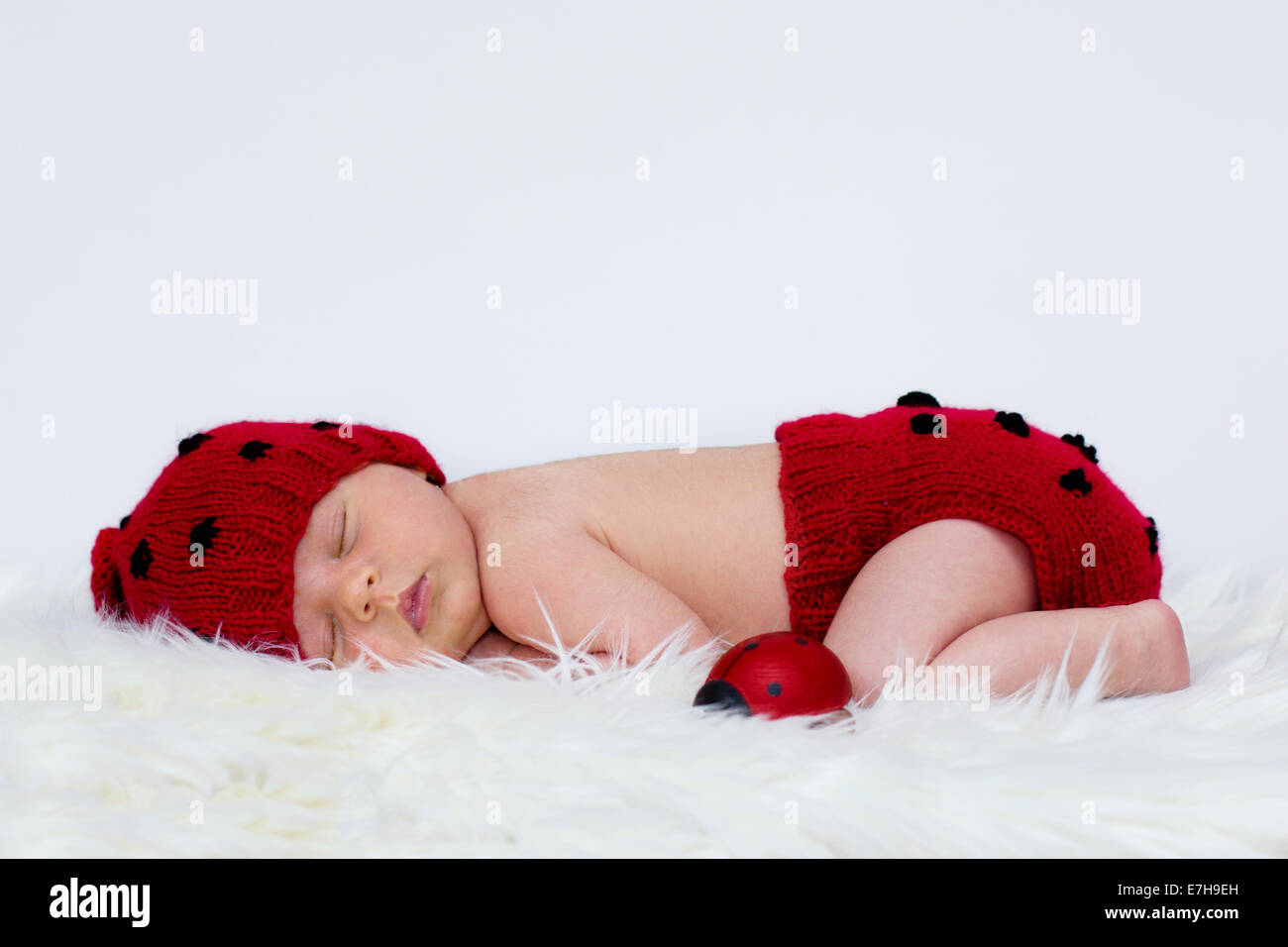 Baby boy in a ladybug hat and pants Stock Photo