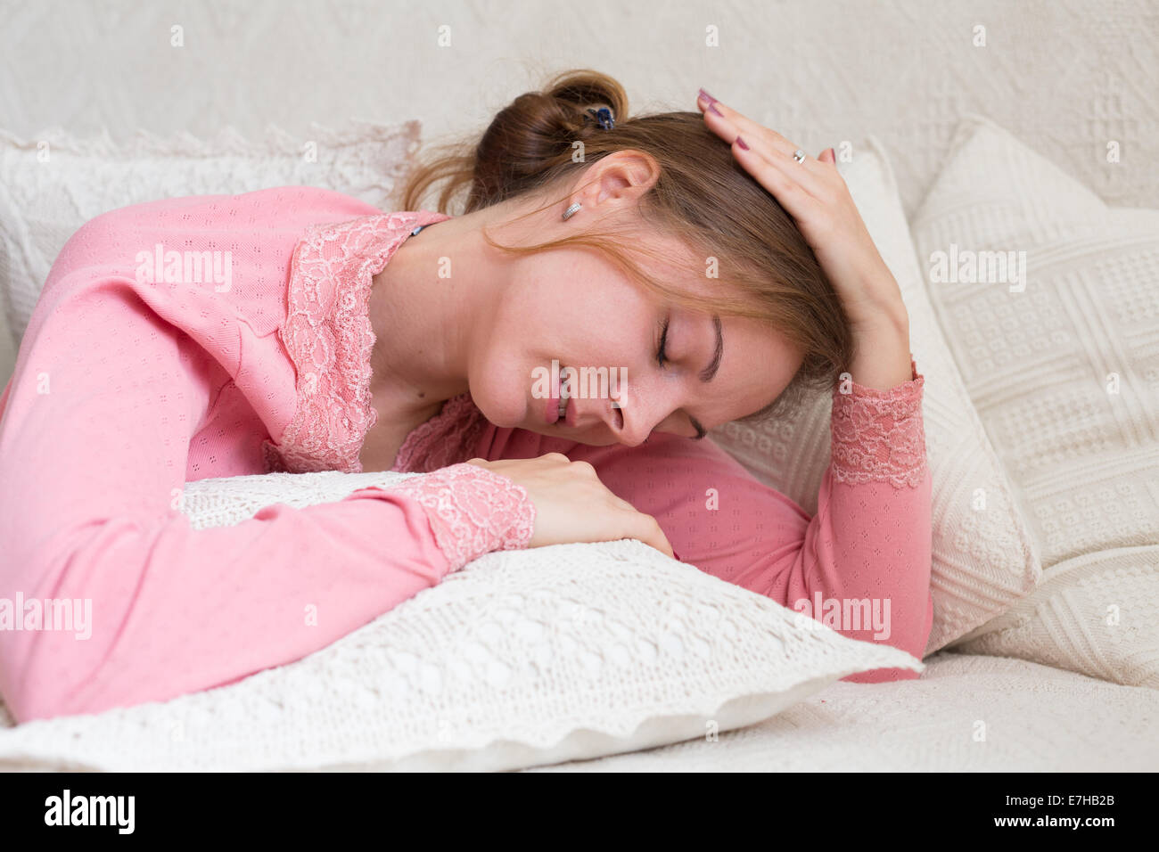 Portrait of woman 20-25 years old lying with closed eyes, stretching neck Stock Photo