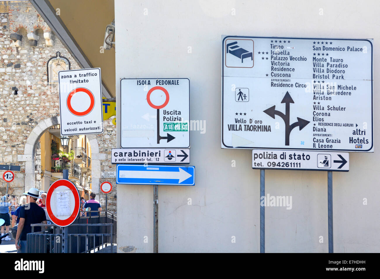 Italian road signs at start of the pedestrianised shopping street Corso Umberto with arched old town gate at Corso Umberto Taormina Sicily Italy Stock Photo