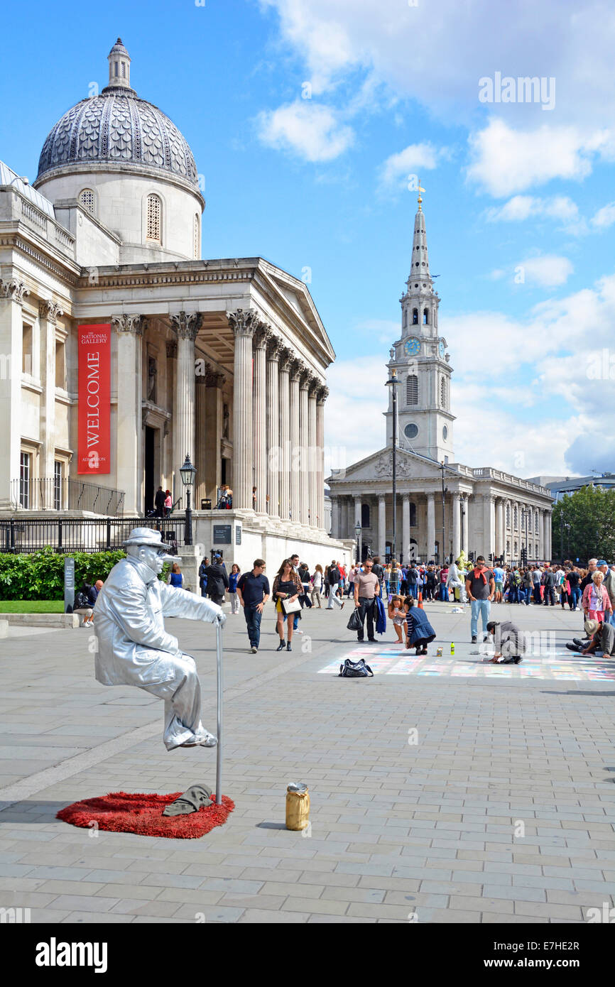 Living street artist person sitting still as statue in makeup & costume apparently invisible support or optical illusion in Trafalgar Square London UK Stock Photo