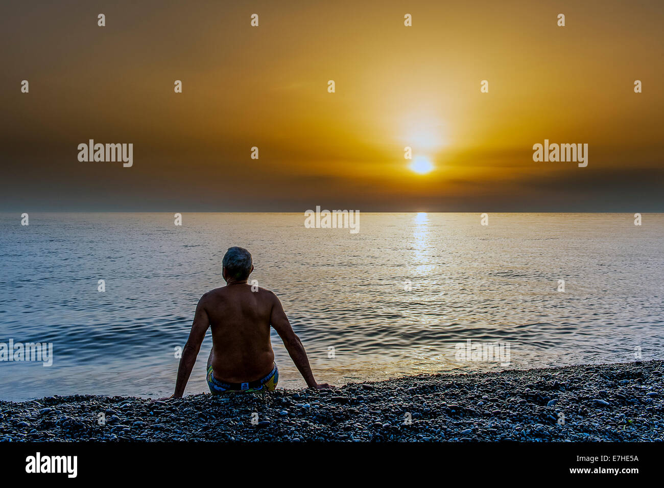 Europe, France, Corsica, Haute Corse, Cap Corse. Nonza. Man in black sand beach at sunset. Stock Photo