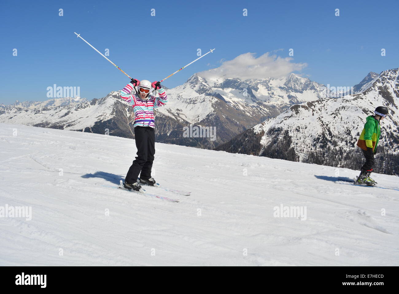 12 year old girl skiing doing ski horns with ski poles. Why do all skiers do this pose? Winter fun Ski holiday Healthy Christmas Stock Photo