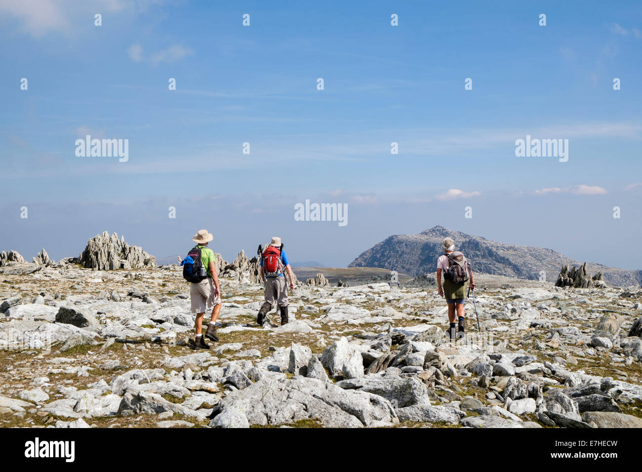 Hikers hiking on mountain top path from Glyder Fawr to Glyder Fach in Glyderau range of mountains of Snowdonia National Park North Wales UK Britain Stock Photo