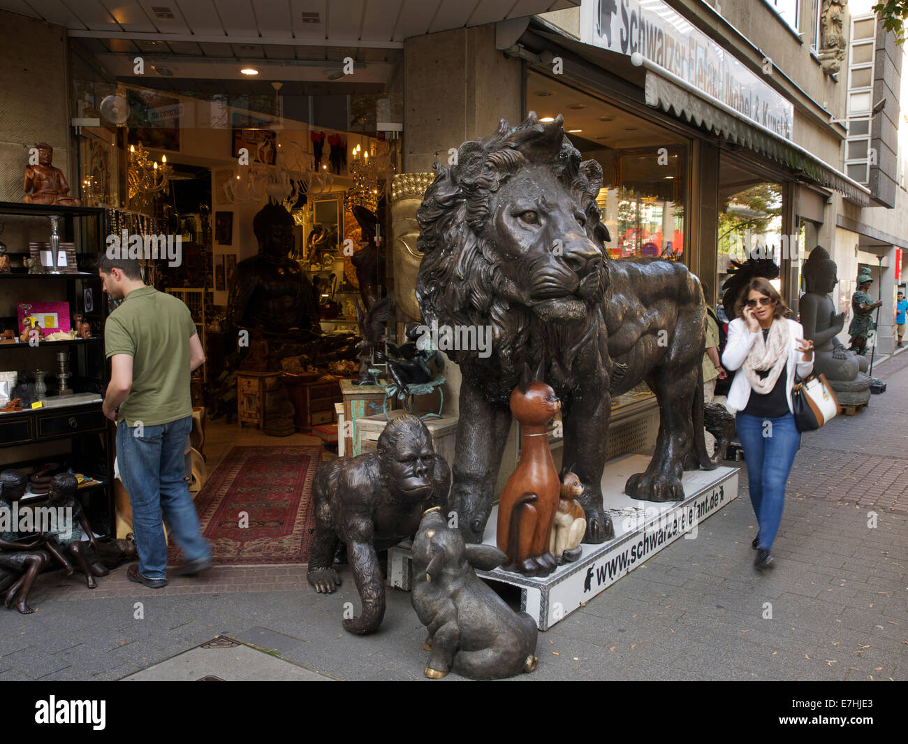Shop in the city center of Cologne with huge bronze lion and people, Cologne, NRW, Germany Stock Photo