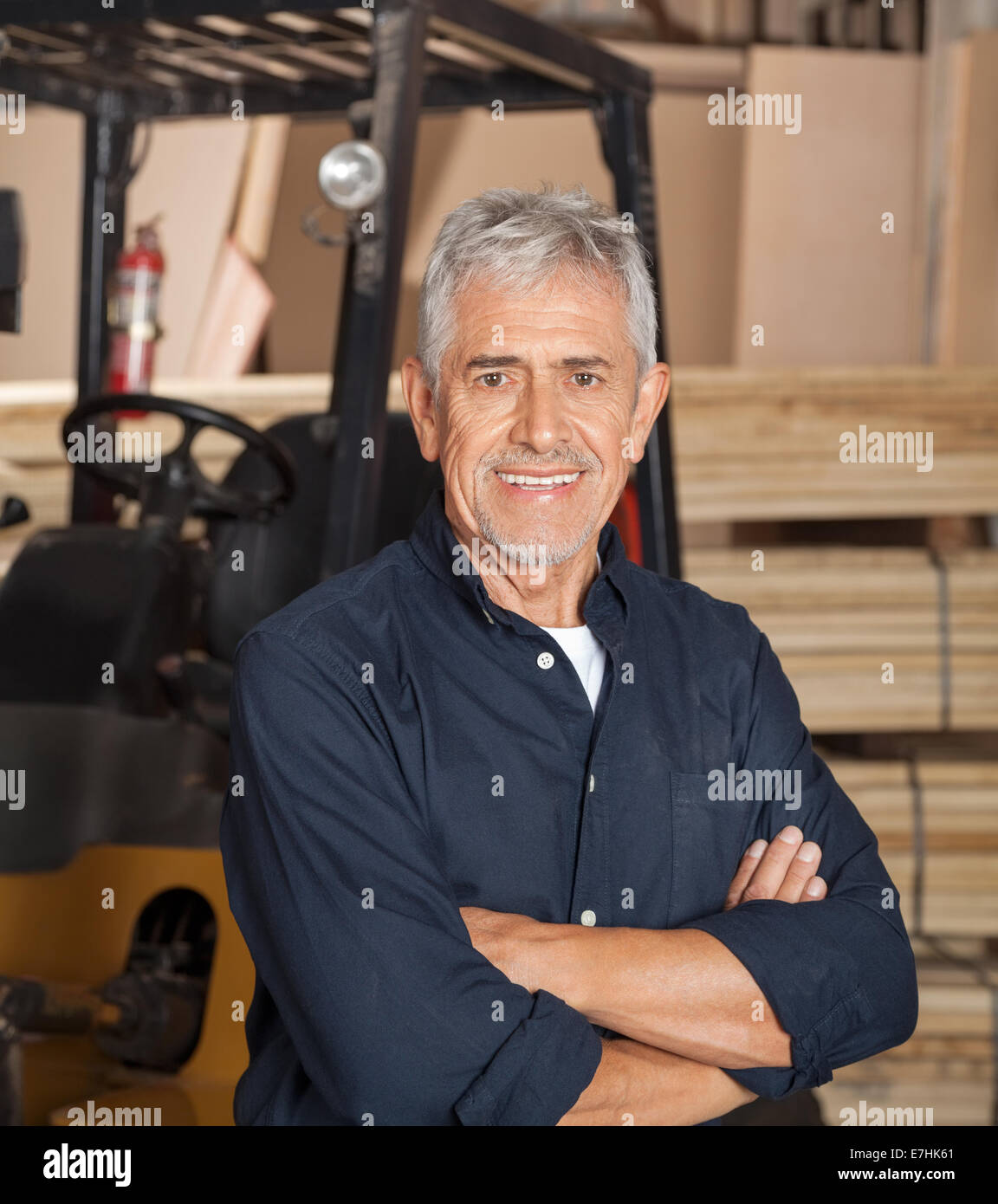 Confident Senior Carpenter With Arms Crossed Stock Photo