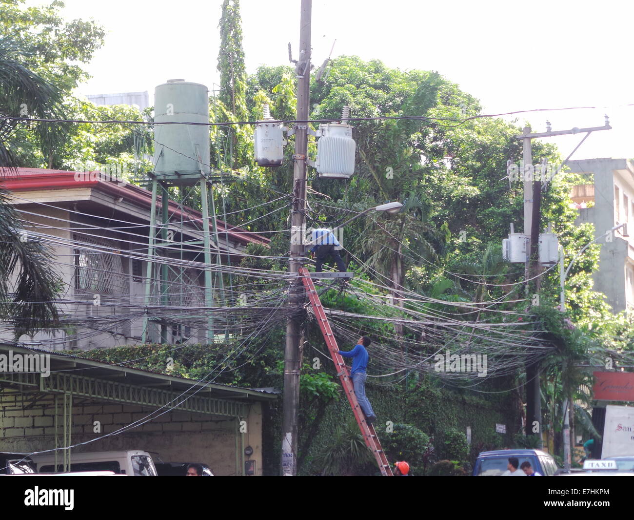 Manila, Philippines. 18 September, 2014. Men from electric company fixing electric cables.  Luzon and Visayas Islands of the Philippines will be experiencing energy crisis on the summer of 2015 according to Energy Secretary Jericho Petilla. Once President Aquino acquires emergency powers from the Congress, Filipino consumers will endure additional increase of 20 centavo per kilowatt hour. The Philippines has the highest electricity cost in Asia-Pacific region. © Sherbien Dacalanio / Alamy Live News Stock Photo