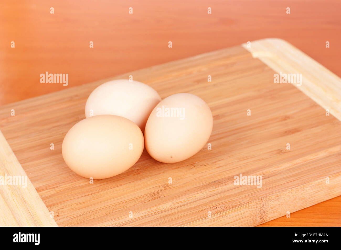 Three brown eggs closeup on wooden background Stock Photo