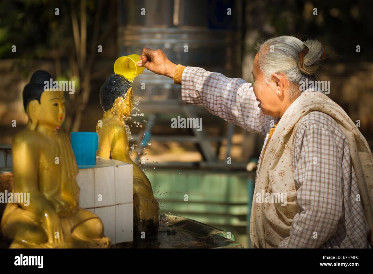 Myanmar (Burma), Mandalay Division, Myinkaba, Gubyaukgyi Temple, woman performing ritual washing of Buddha statue Stock Photo