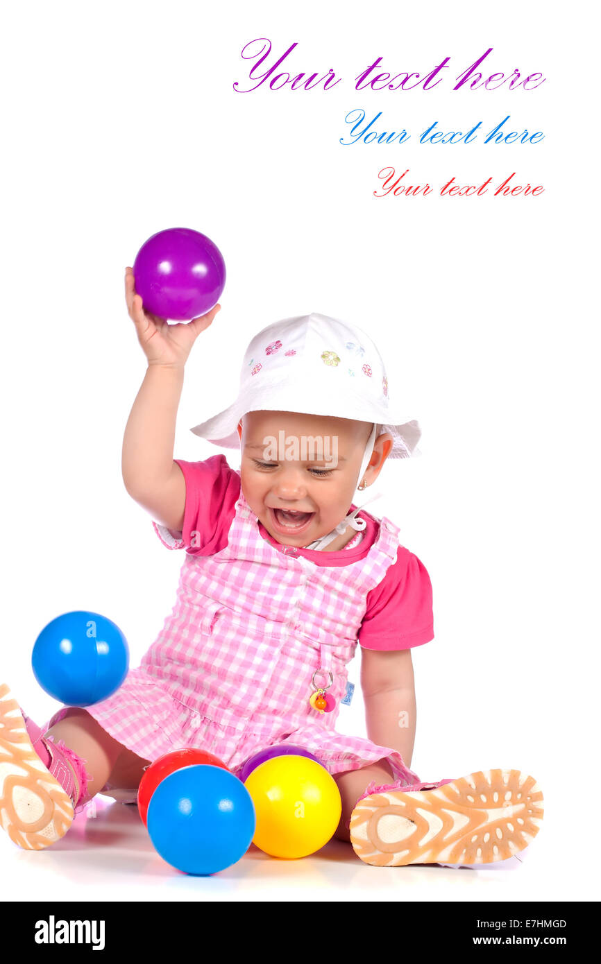 Cute baby girl playing with colorful balls in studio isolated over white background Stock Photo