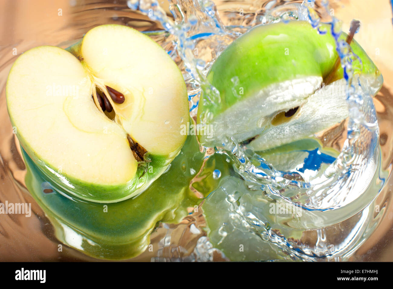 Green apple causing water splash Stock Photo