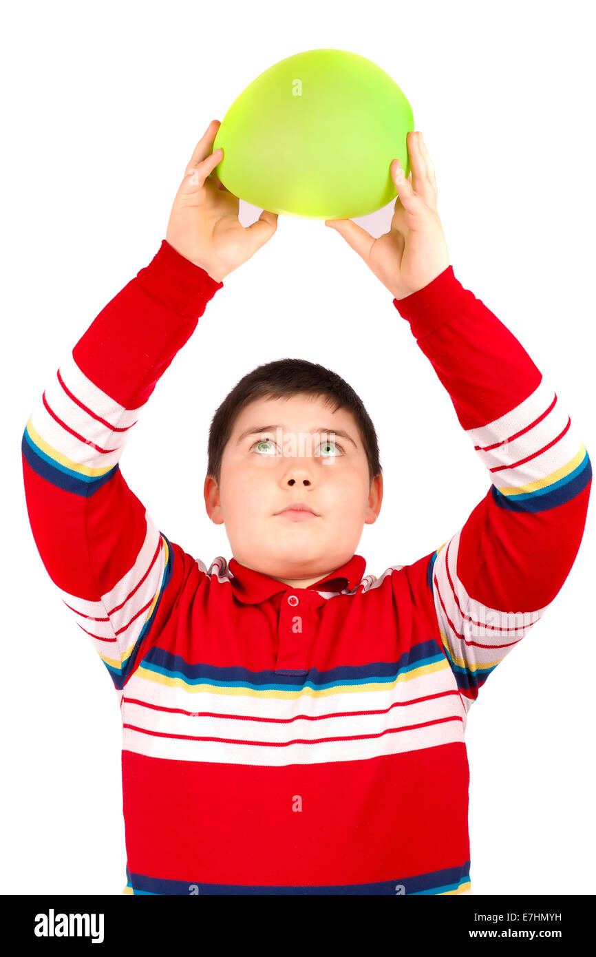 Boy who keeps a green balloon overhead, isolated over white background Stock Photo