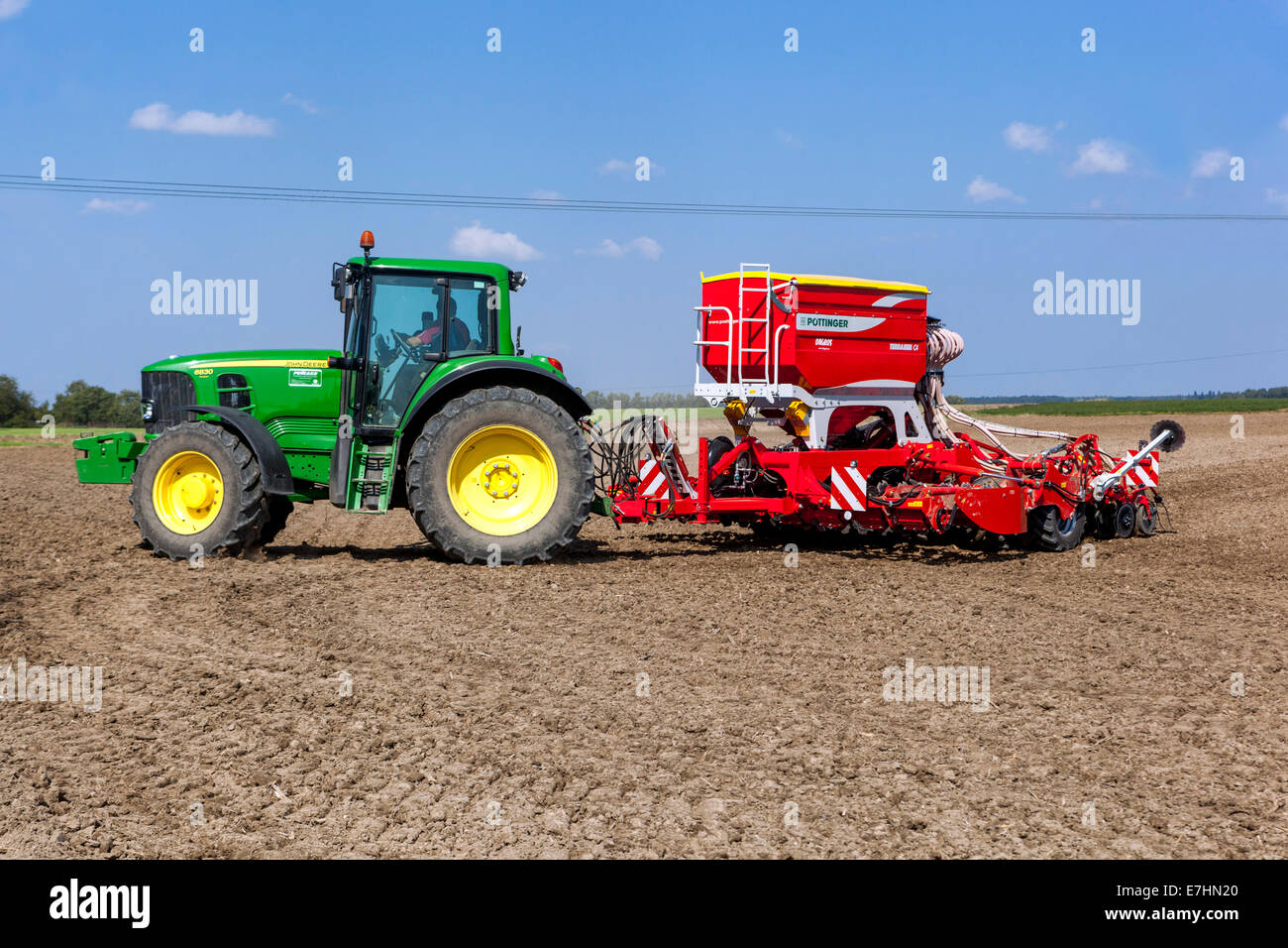 Seed drill tractor John Deere tractor sowing seeds wheat on a field Czech Republic farmer Stock Photo