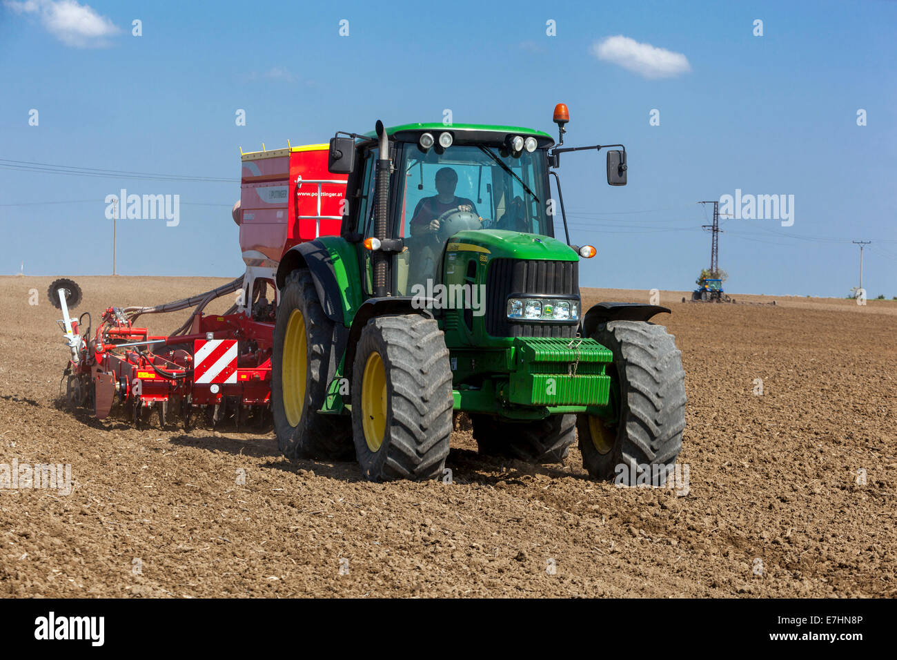 John Deere tractor sowing seeds on a field Stock Photo