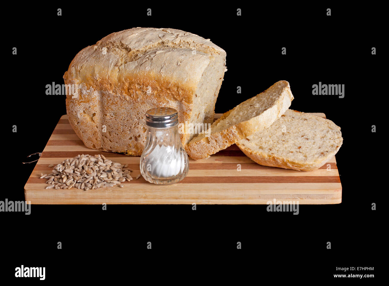 Fresh bred and some seeds on a cutting board isolated over black background Stock Photo