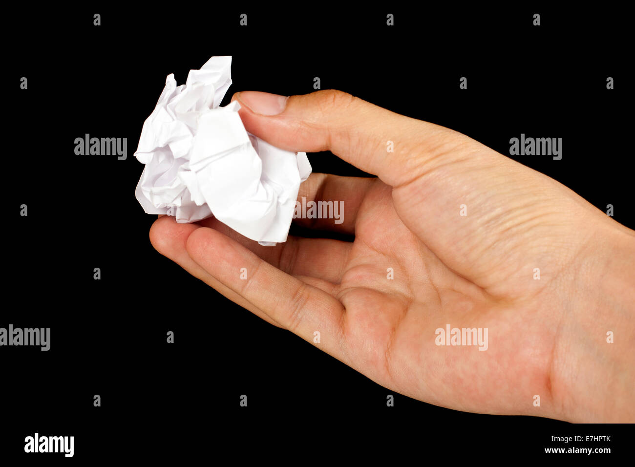Hand with a crumpled paper ball over black background Stock Photo Alamy