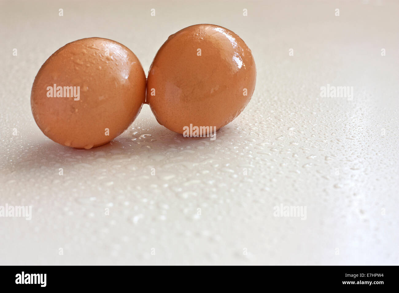 Two eggs and some water drops beside Stock Photo