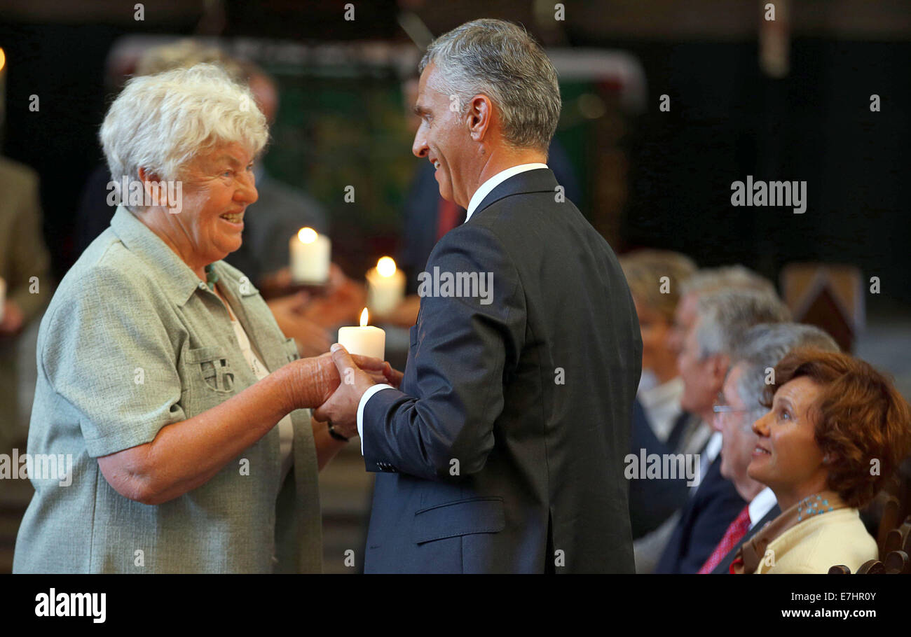 Former GDR civil rights activist Dietlinde Glueer hands a candle to Swiss president Didier Burkhalter at the end of the 11th meeting of the German-speaking heads of state in Rostock, Germany, 18 September 2014. They are discussing questions about demographic change and remembering the peaceful revolution in East Germany 25 years ago at the informal meeting. Photo: JENS BUETTNER/dpa Stock Photo