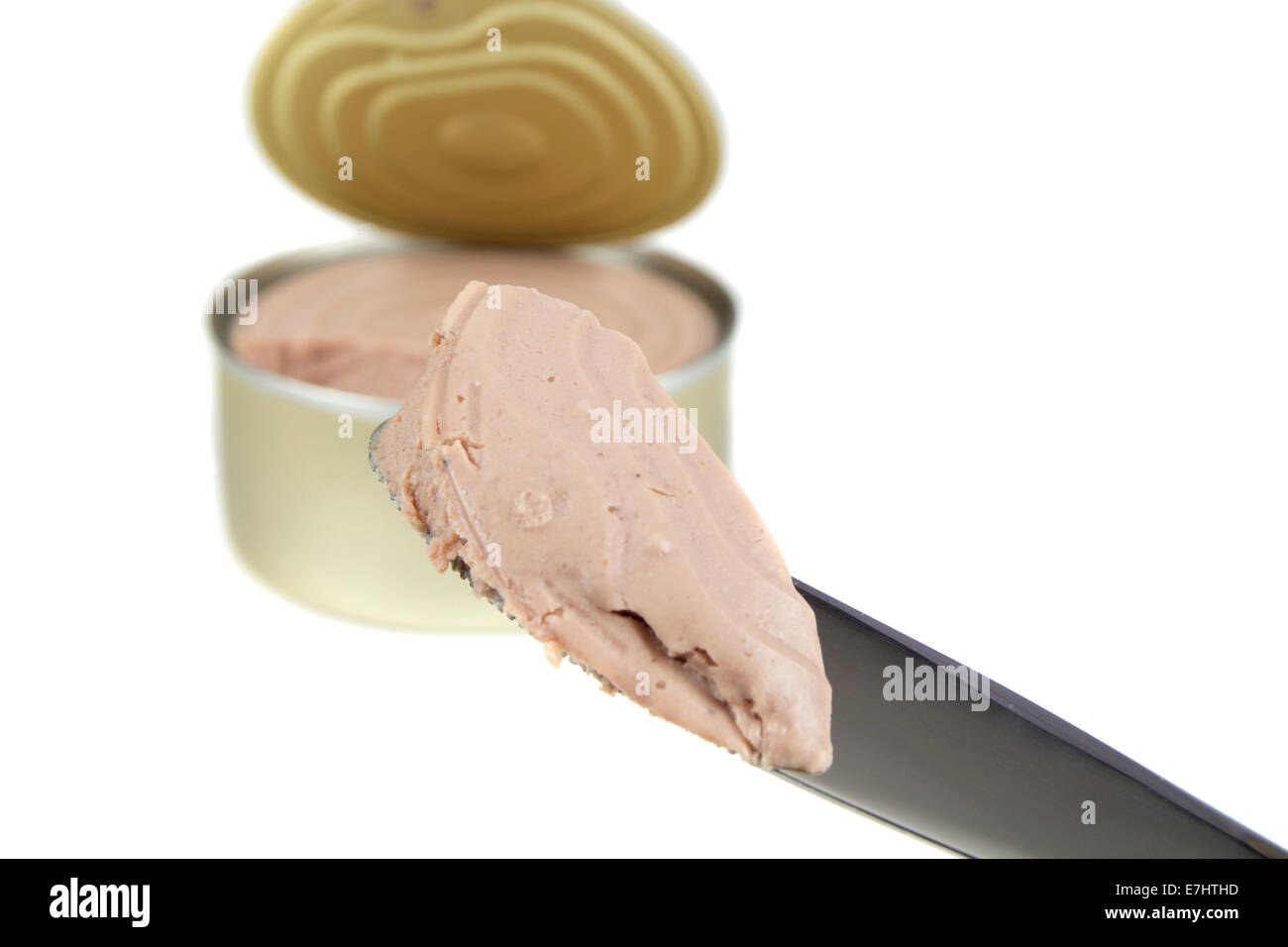 Knife with pork pate and a blurred canned Stock Photo