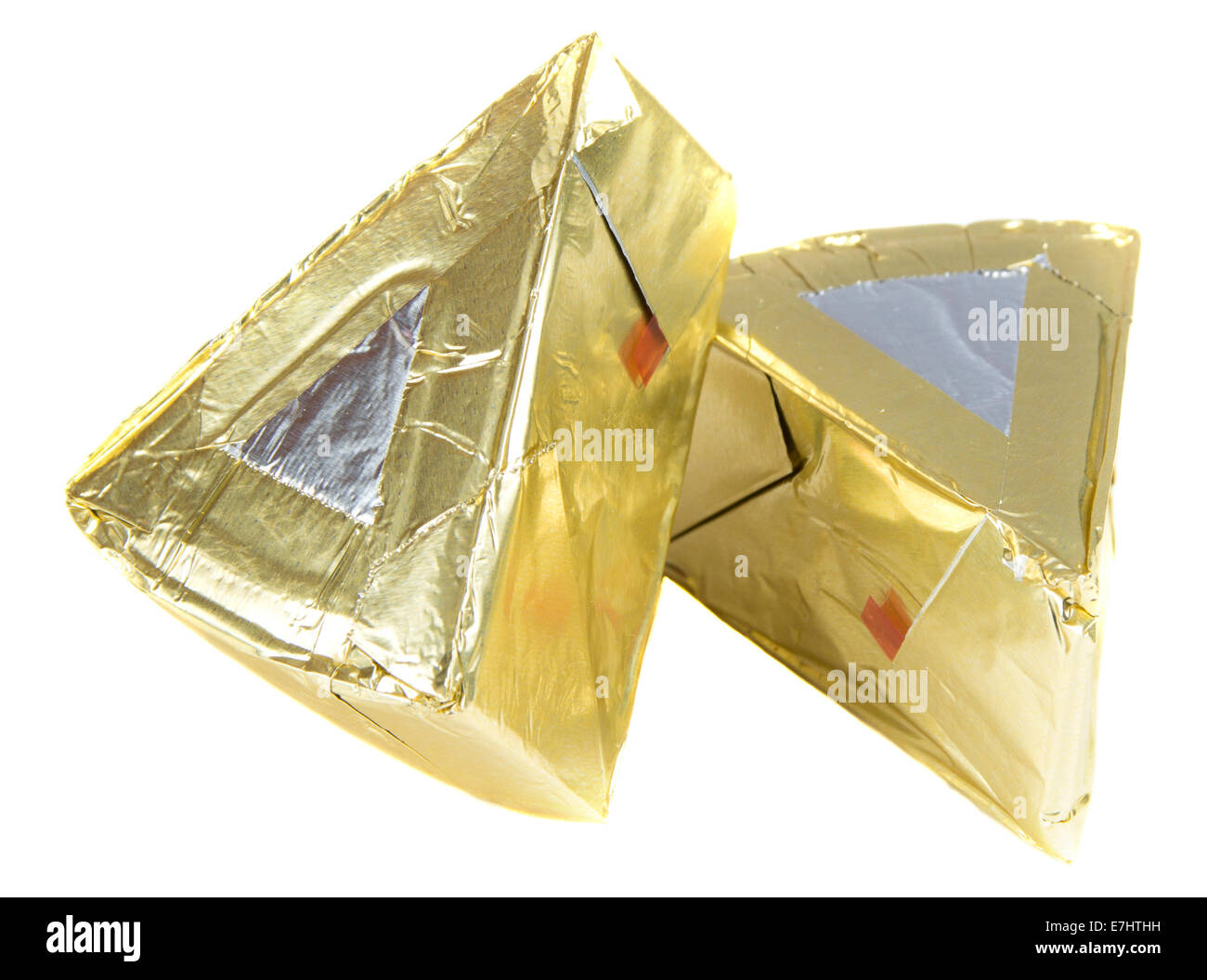 Piece of cheese in triangle foil over white background Stock Photo