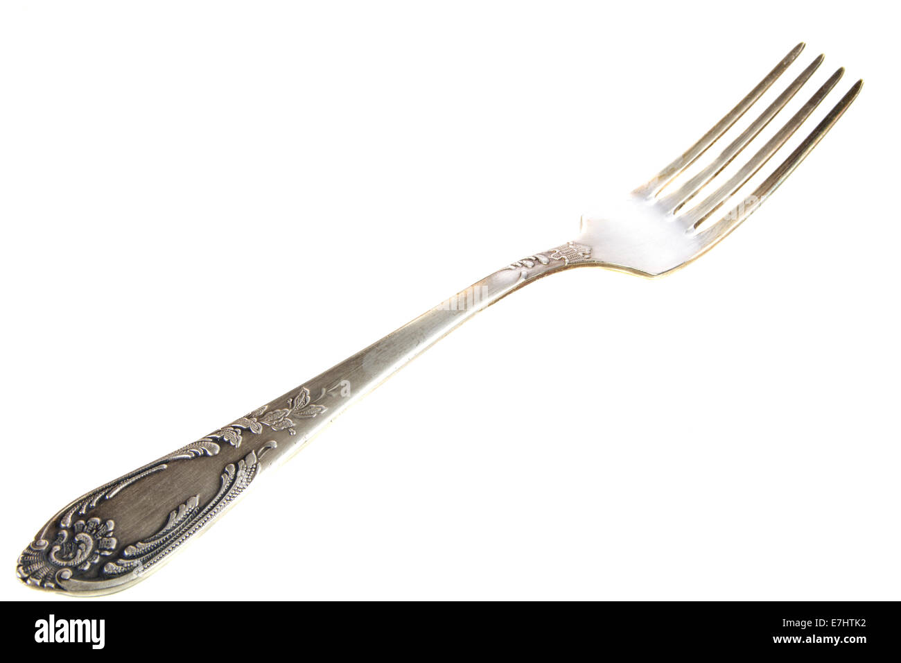 Old silver fork with ornaments on isolated white background Stock Photo