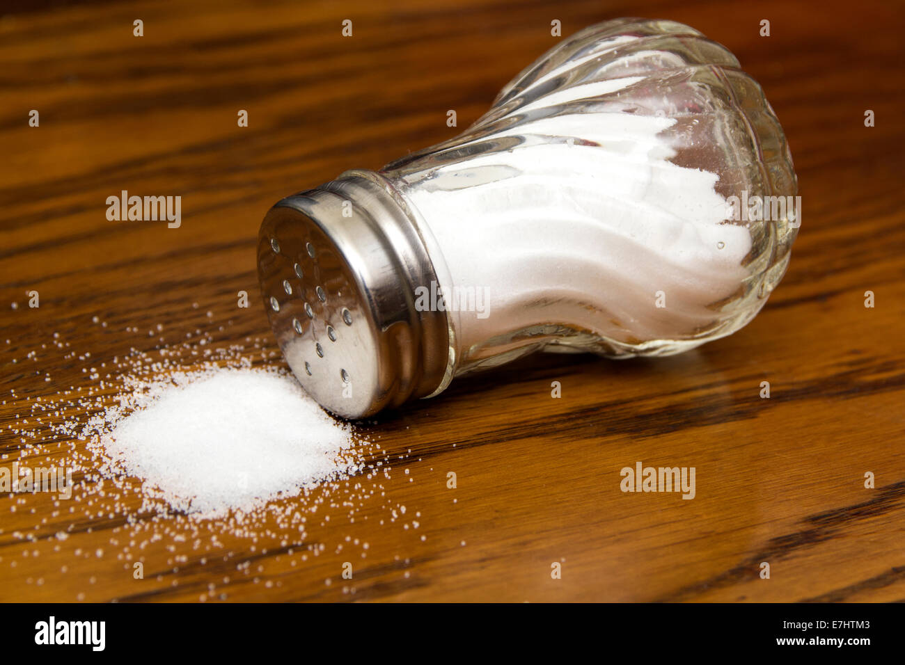 Salt shaker on a dark wood table Stock Photo