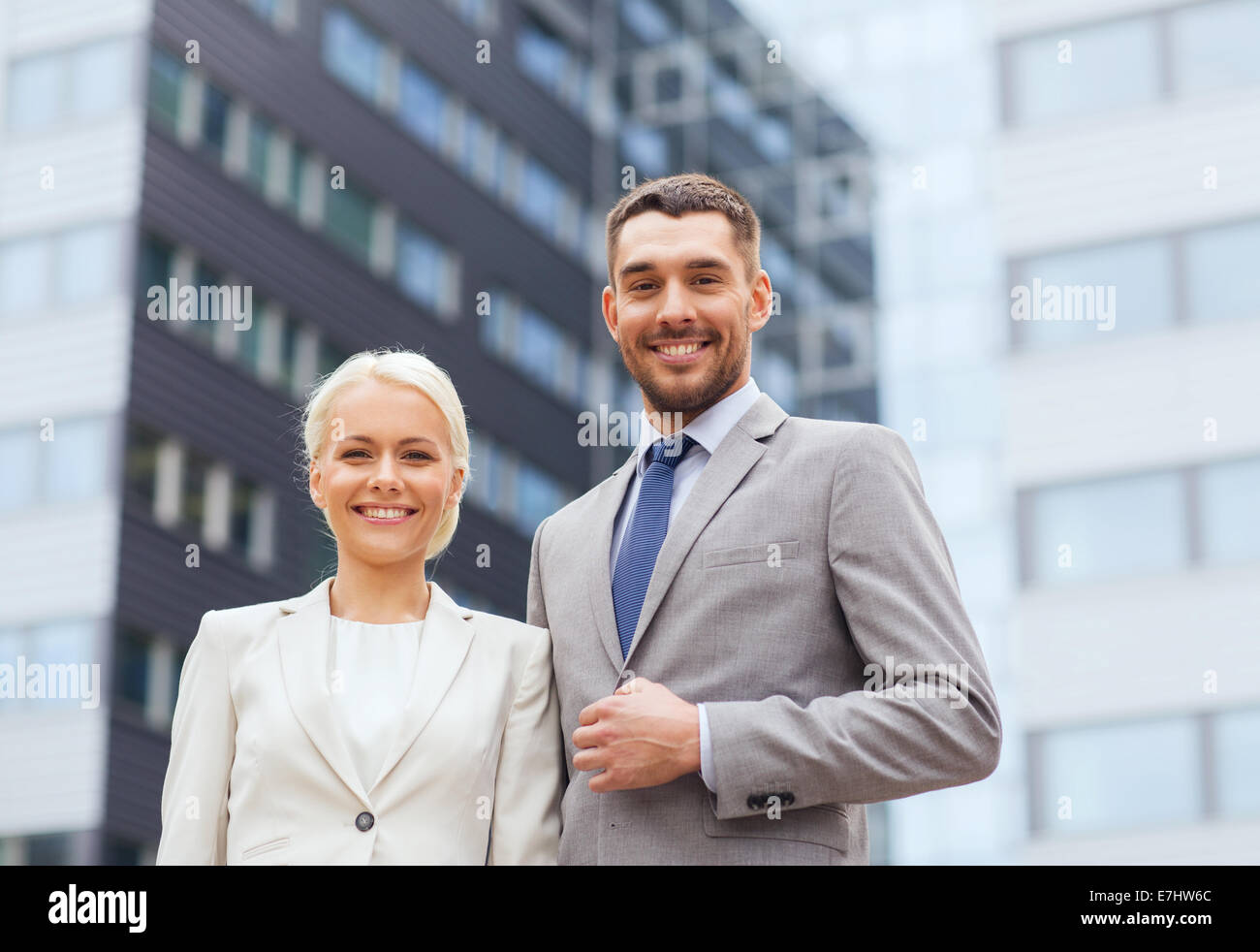 smiling businessmen standing over office building Stock Photo - Alamy