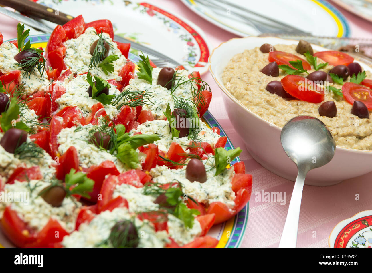 Stuffed tomatoes with cheese and eggplant salad on table Stock Photo