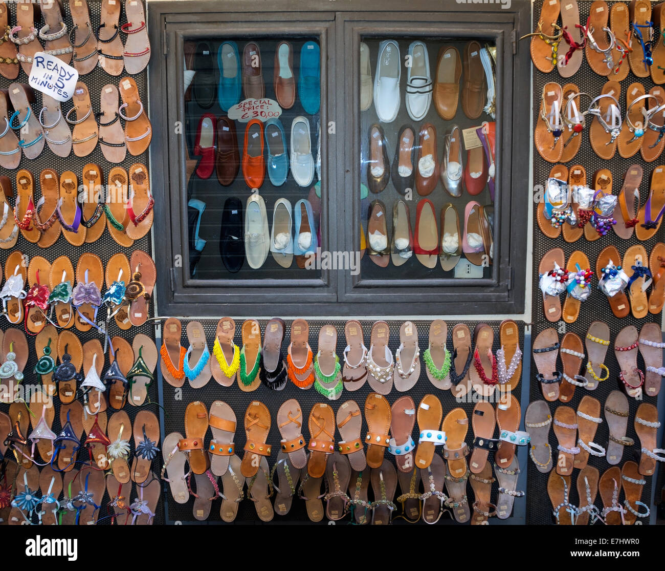 Ladies sandals for sale, displayed on a wall outside the workshop where they are made by hand. Stock Photo