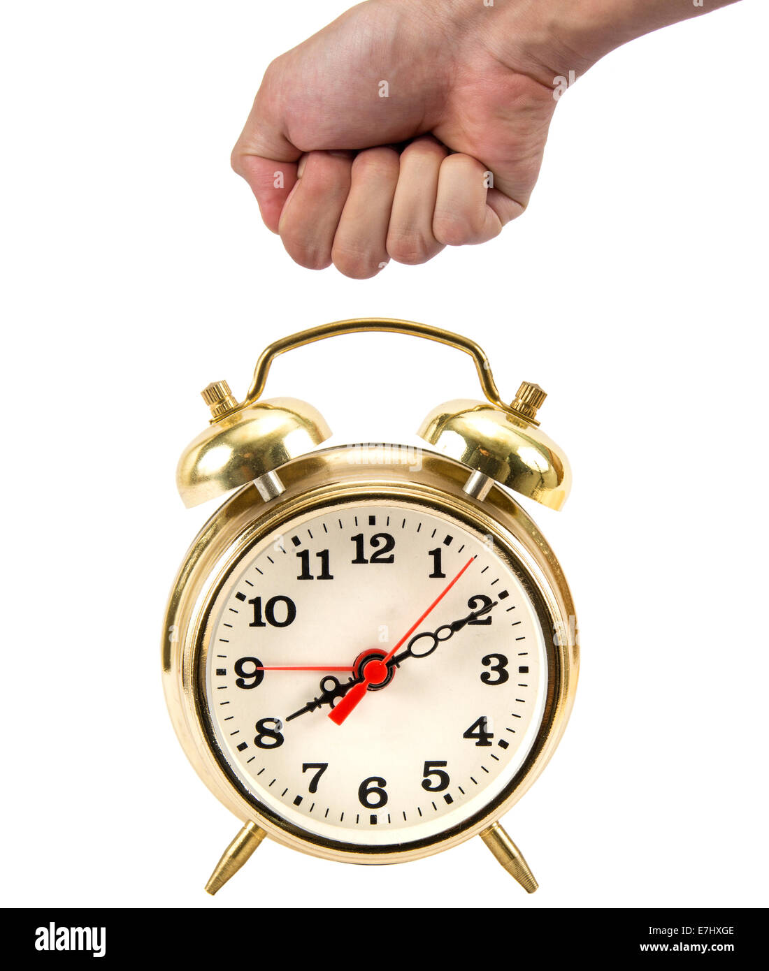 Man's hand in a fist about to hit a gold alarm clock isolated on white Stock Photo
