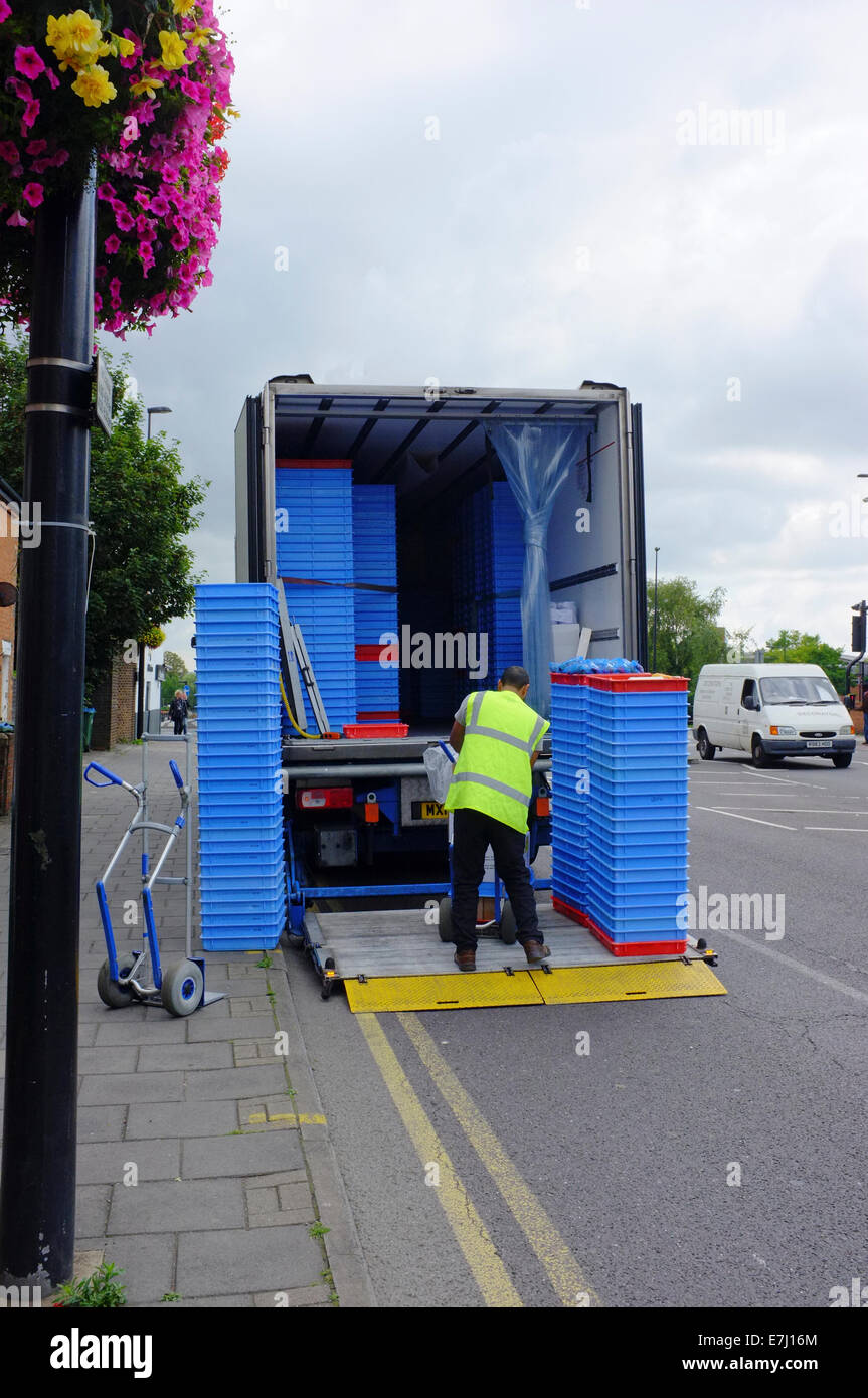 man unloading a truck on a road with double yellow lines Stock Photo