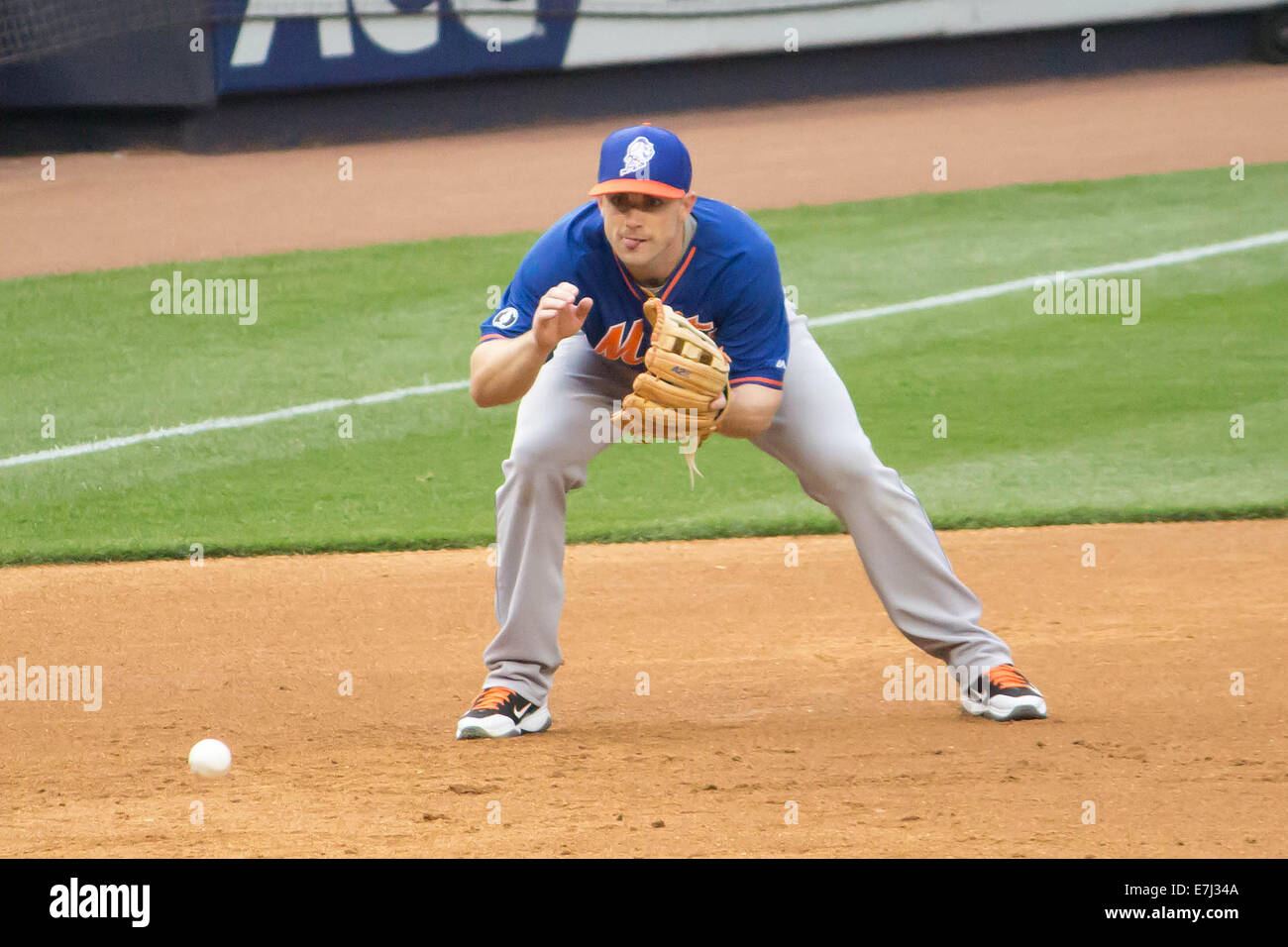 This image shows NY Mets third baseman and superstar David Wright fielding  a ball against the NY Yankees at Yankee Stadium Stock Photo
