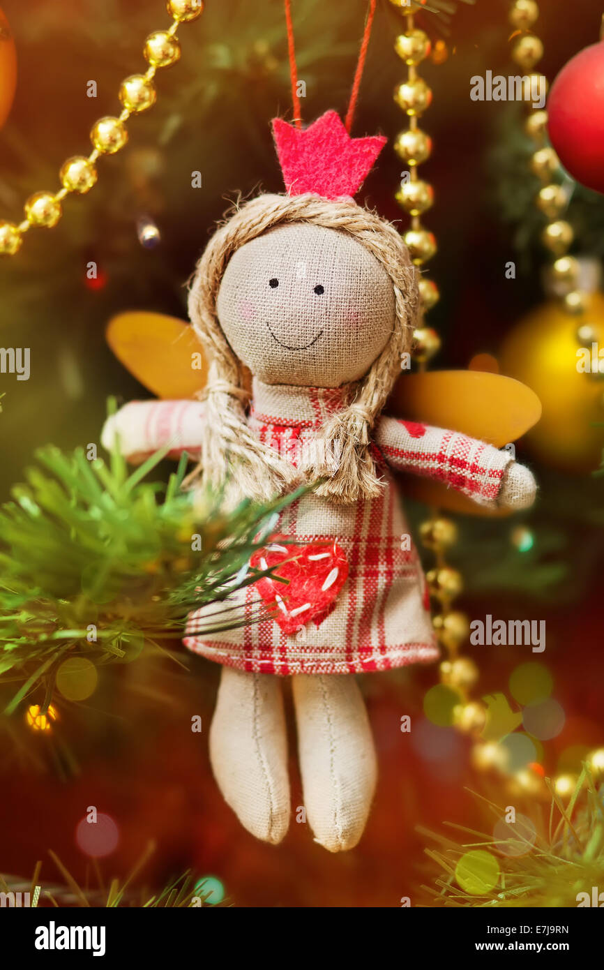 Handmade Christmas angel with tinsel decoration on fir-tree Stock Photo