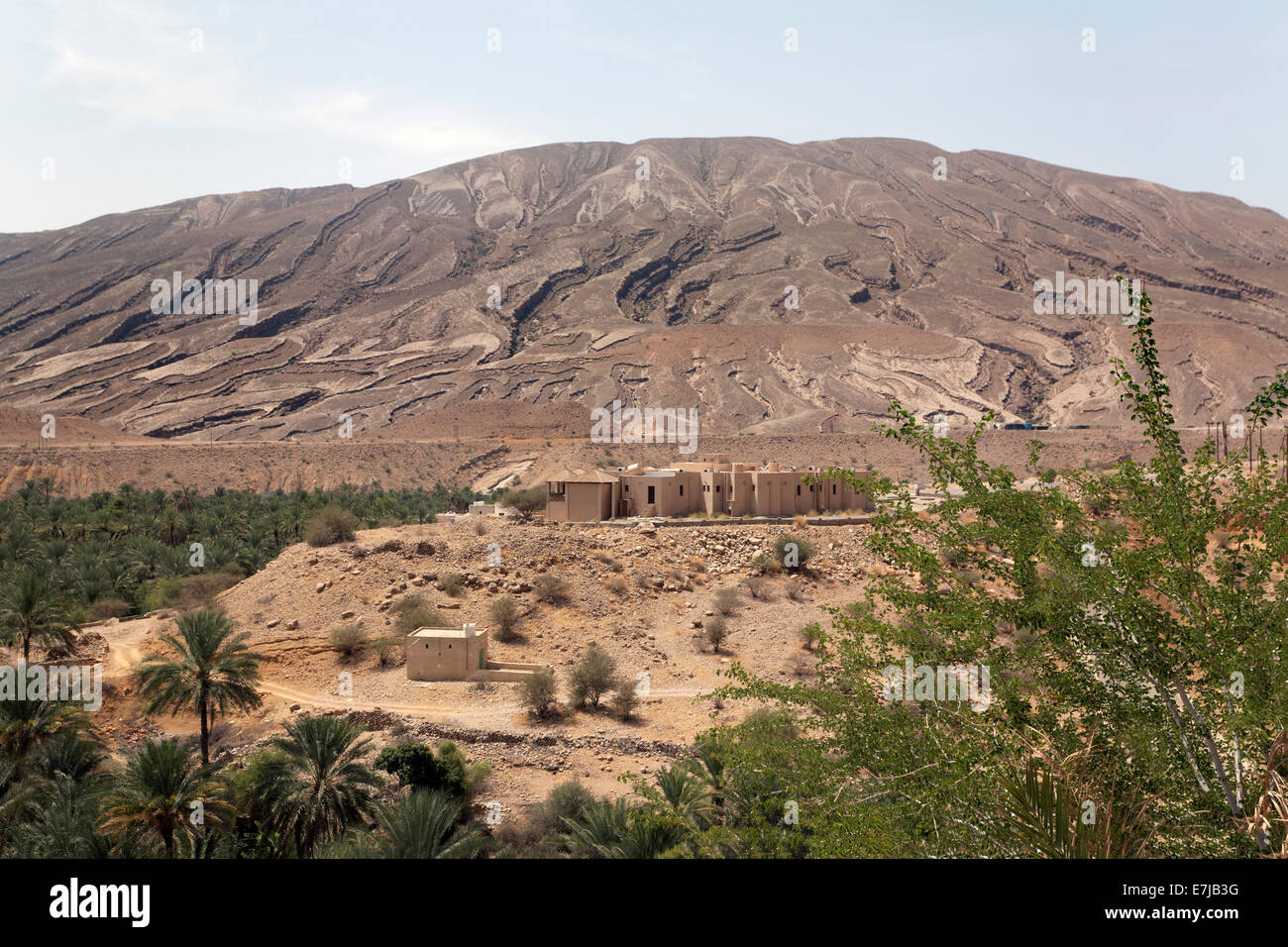 Hill with deep cuts from erosion, settlement, date palms, Sur, Ash Sharqiyah province, Sultanate of Oman, Arabian Peninsula Stock Photo