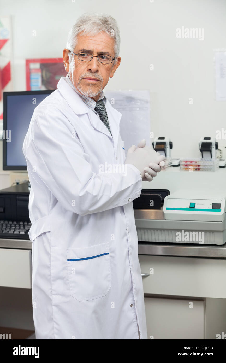 Scientist Standing By Analyzer In Lab Stock Photo