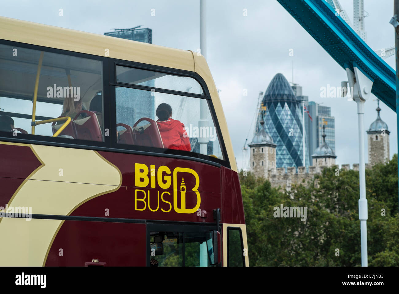 Tour Bus crosses Tower Bridge with the City of London in the background Stock Photo