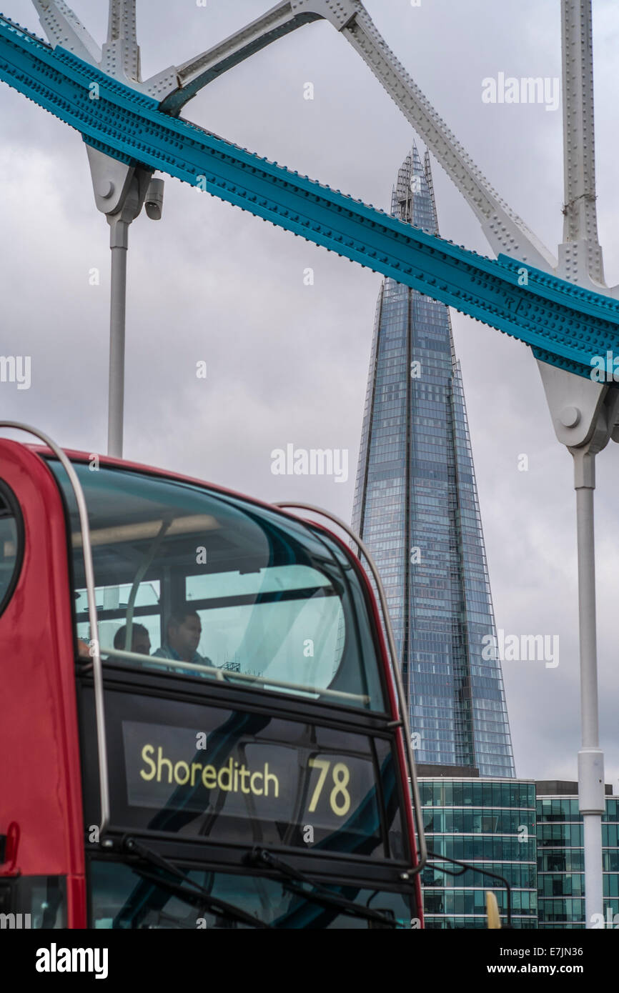 A red bus crosses Tower Bridge with the Shard London in the background Stock Photo