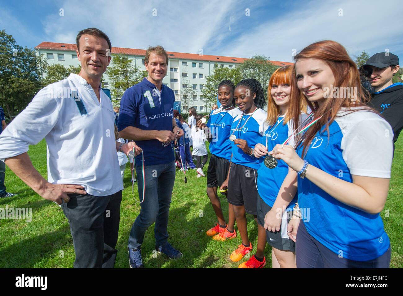 Laureus ambassadors, the soccer coach and former goalkeeper Jens Lehmann (2-L) and soccer coach Fredi Bobic (L) stand together with coaches of the project 'Kicking Girls' at the sports field of the primary school Bad-Soden-Strasse in Munich, Germany, 19 September 2014. Ambassadors of the Laureus foundation visit children and coaches of the project 'Kicking Girls' which offers sport working-groups at schools for girls with a migratory background. Photo: Tobias Hase/dpa Stock Photo