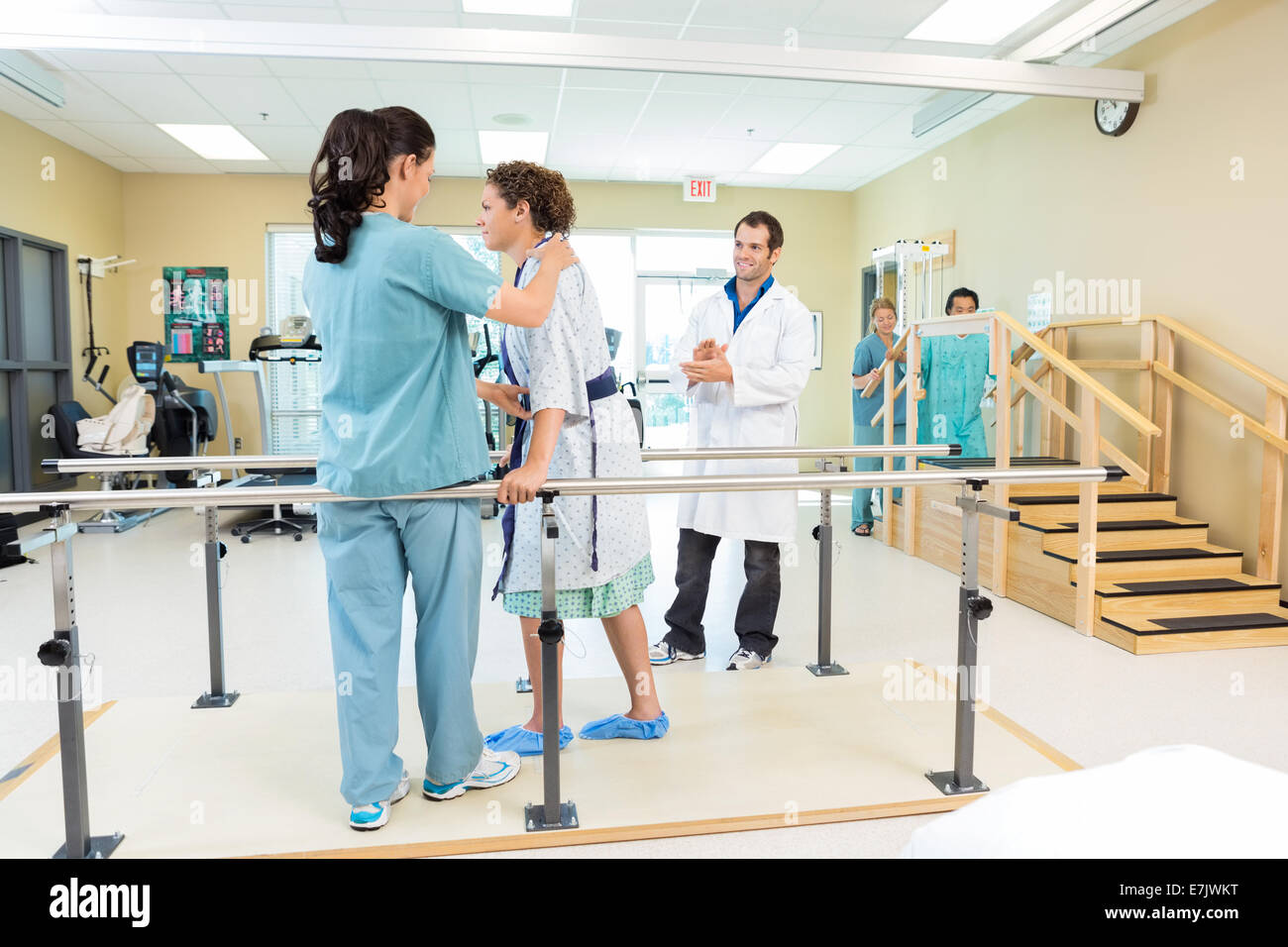 Physical Therapist Assisting Patient In Walking Stock Photo