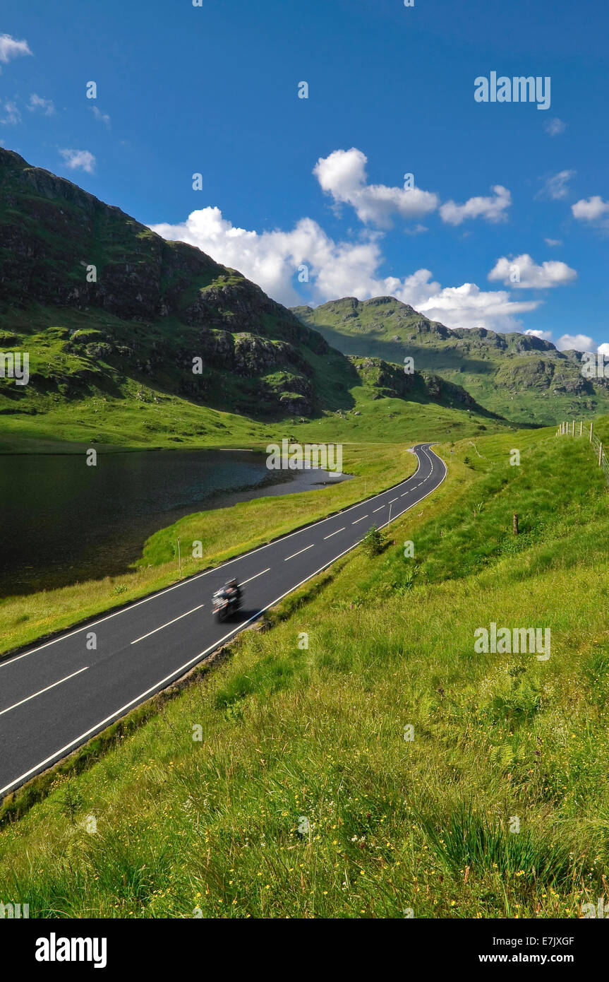 Speeding motorbike on mountain road in Scotland. Road A83 Argyll and Bute, Loch Restil Stock Photo