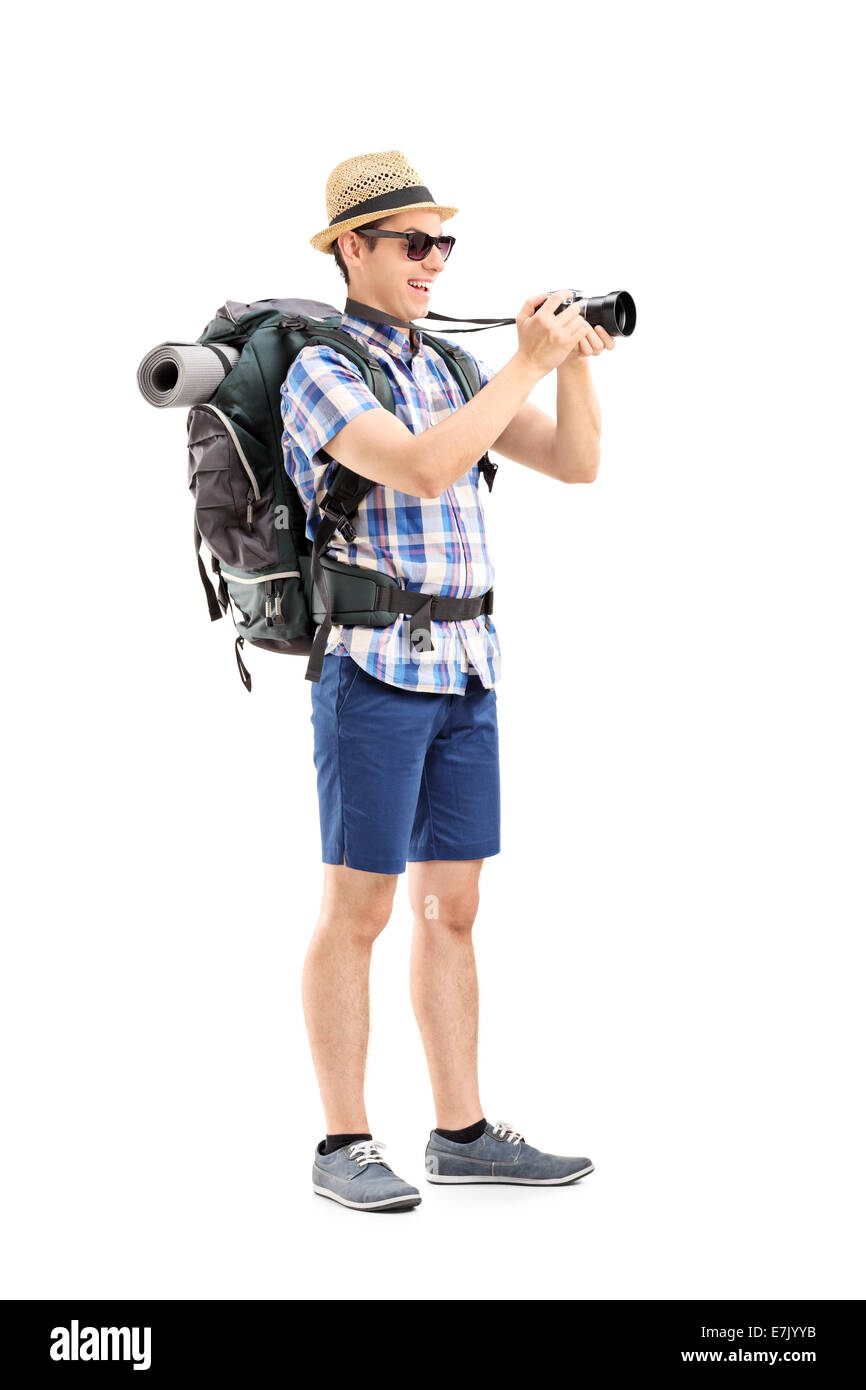 Full length portrait of a male tourist taking a picture with a camera isolated on white background Stock Photo