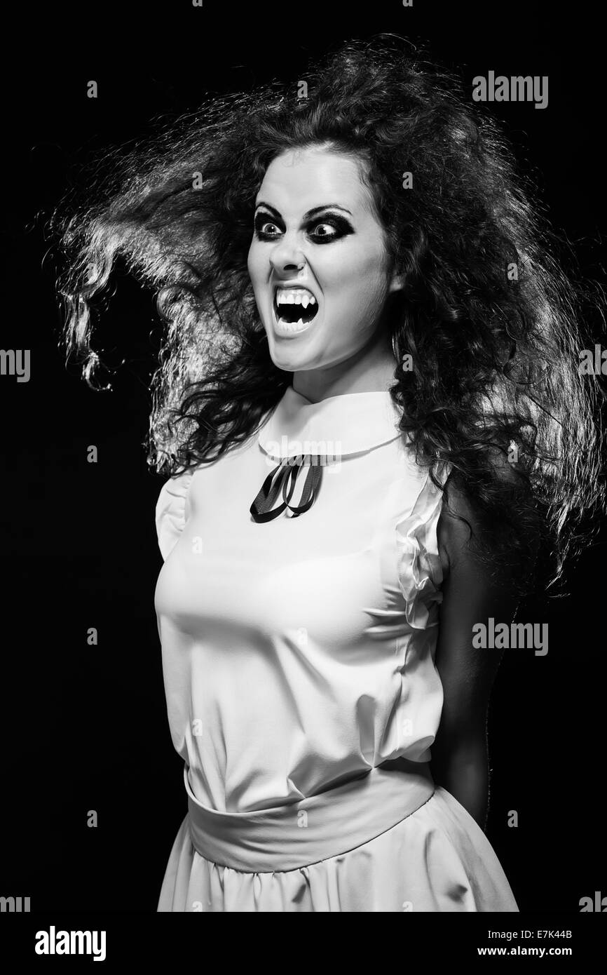 angry screaming vampire woman in dark, monochrome image Stock Photo