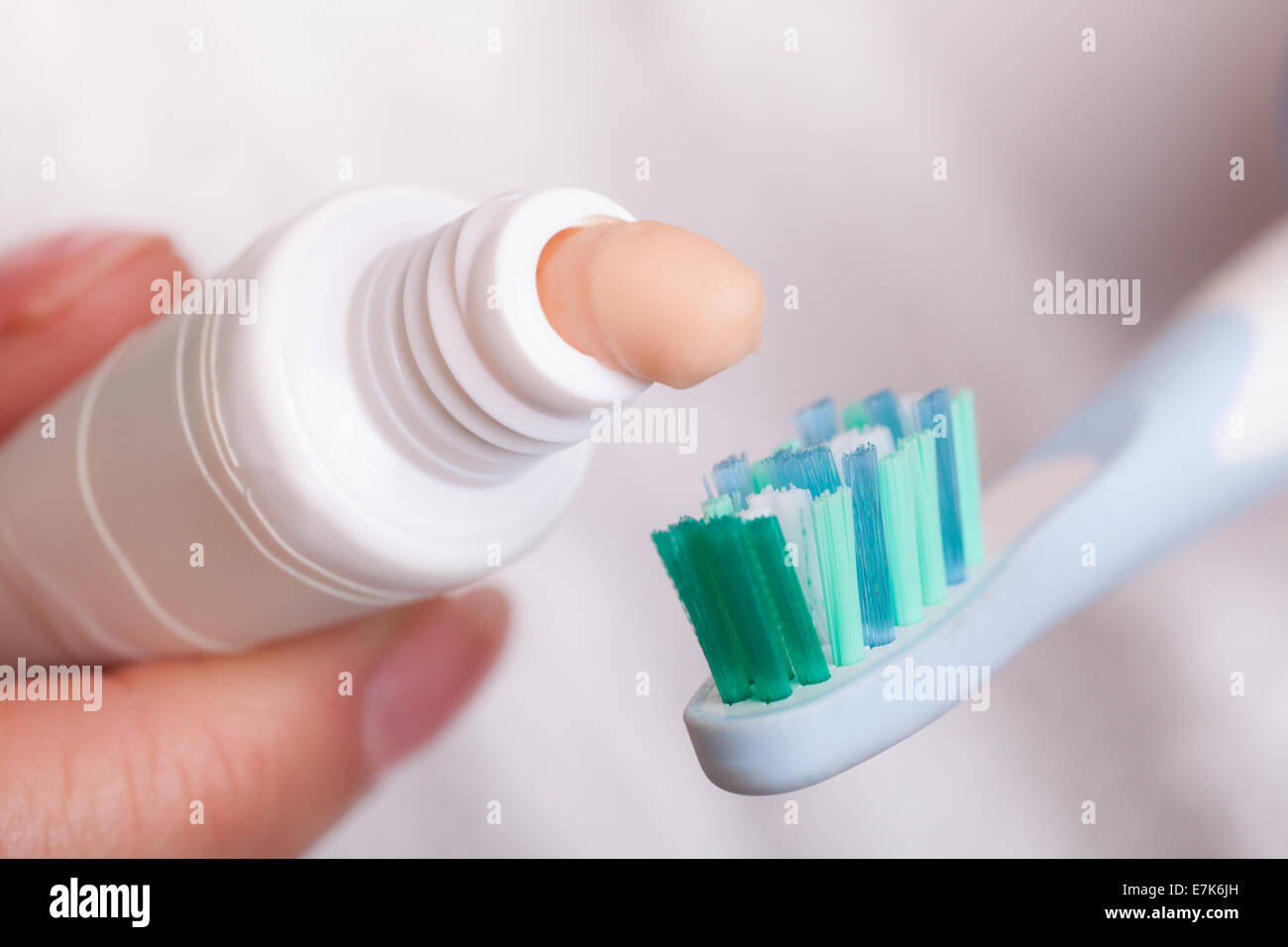 Closeup of toothbrush and toothpaste tube in female hands. Daily dental ...