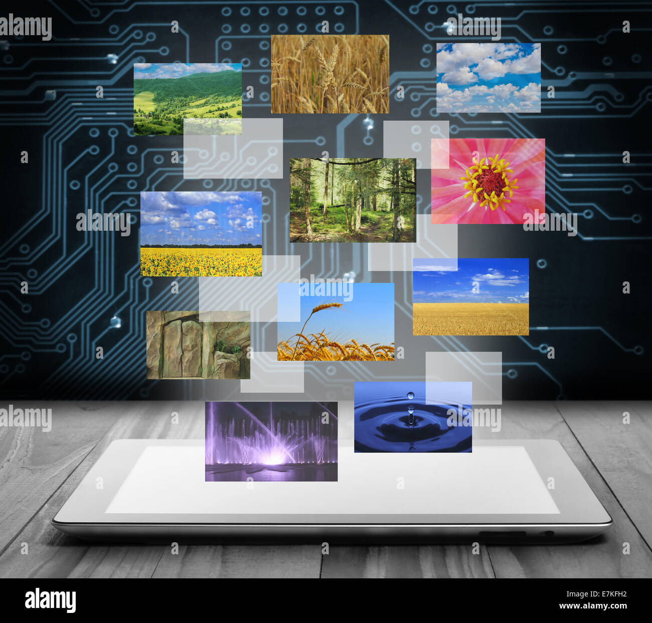 Tablet pc with flying pictures on digital background Stock Photo