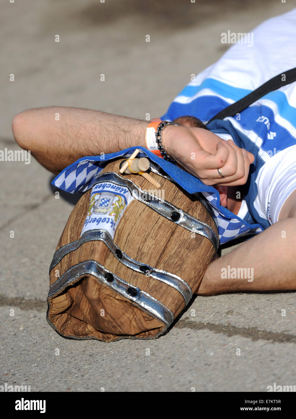 Munich, Germany. 20th Sep, 2014. A drunken man sleeps outside of a festival tent during the opening day of Oktoberfest in Munich, Germany, 20 September 2014. The Munich beer festival continues until 05 October 2014. Photo: ANDREAS GEBERT/dpa/Alamy Live News Stock Photo