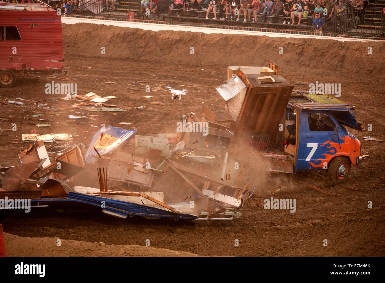 Brightly painted motor home disintegrates in a demolition derby at dusk