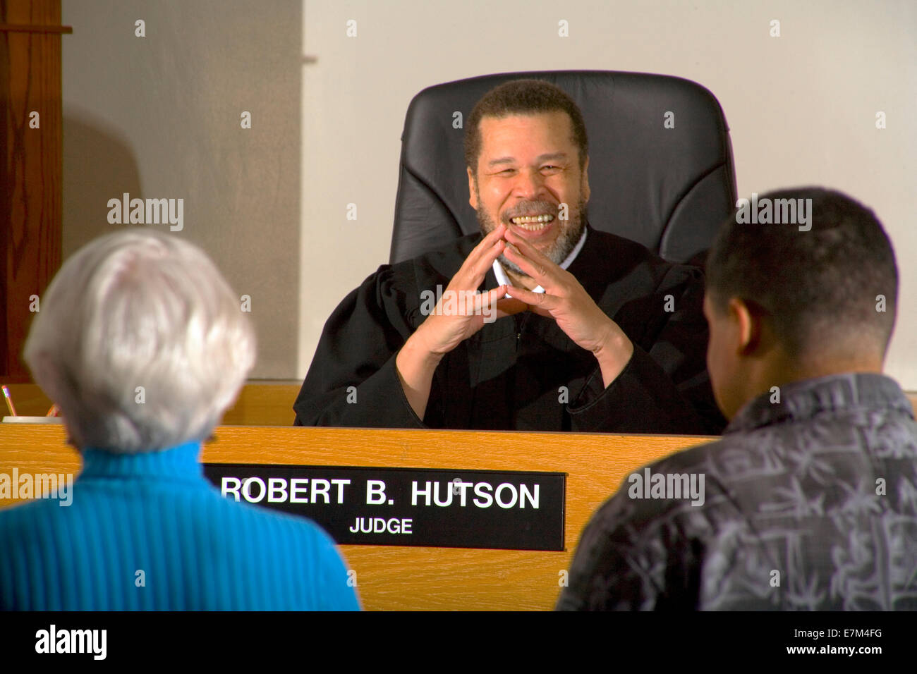 A teenage defendant accompanied by a court appointed lawyer appears at