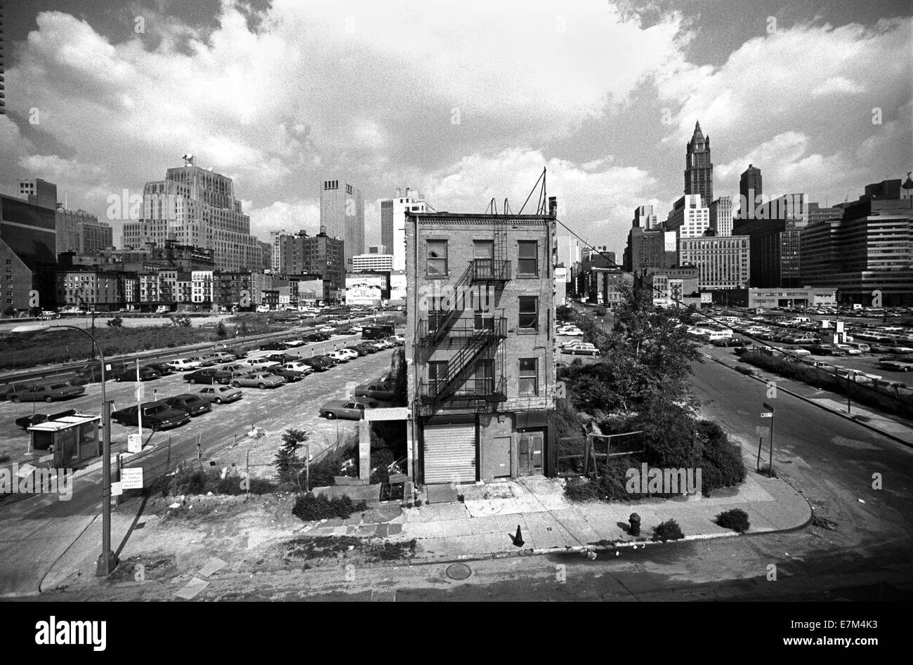 Taking a stand against urban renewal, the stubborn owner of a single building on New York City's lower west side of Manhattan has refused to make way for new construction in 1978. Note Woolworth Building in right background. Stock Photo