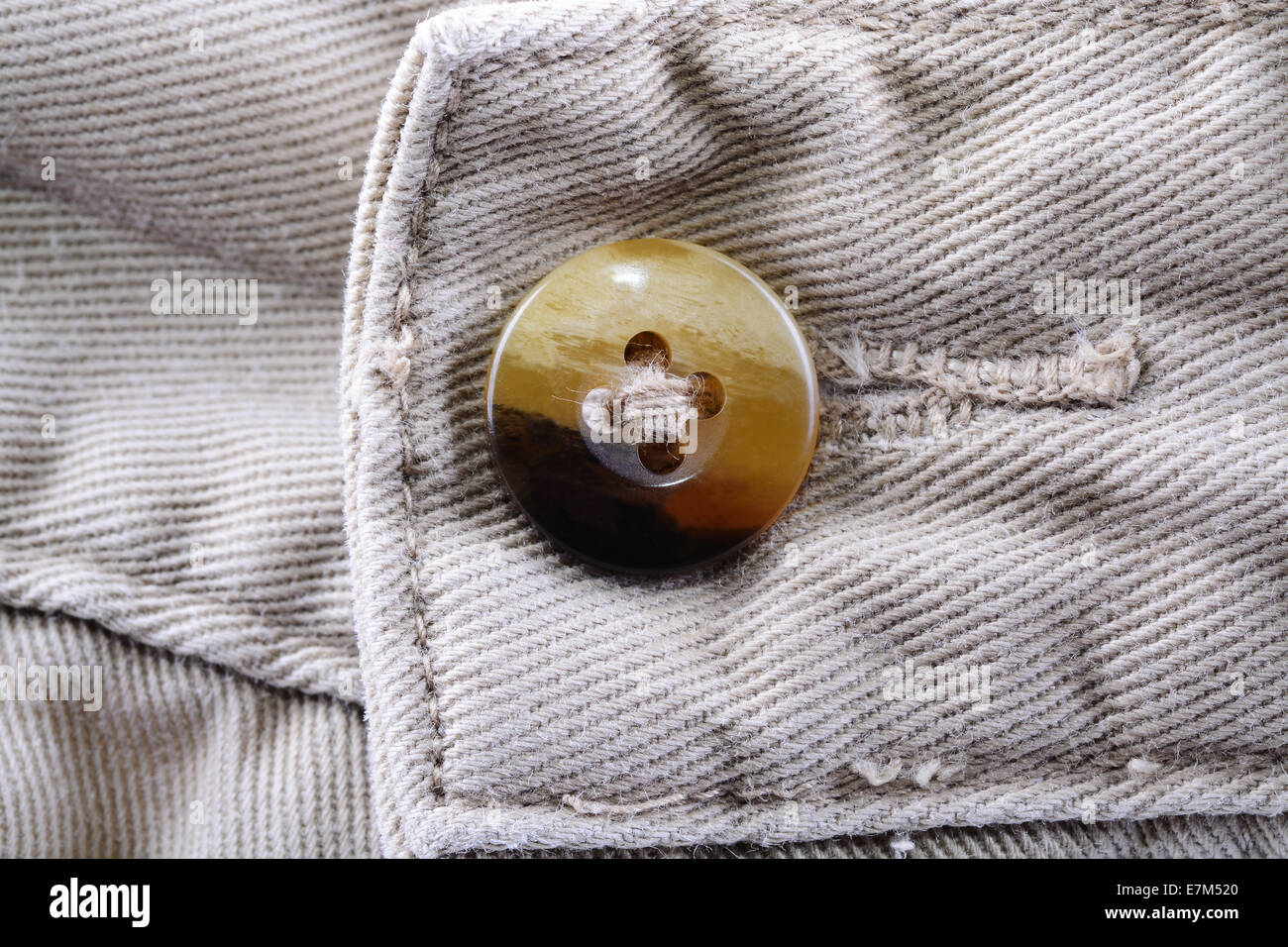 Macro shot of a button on a pair of man khaki trousers Stock Photo