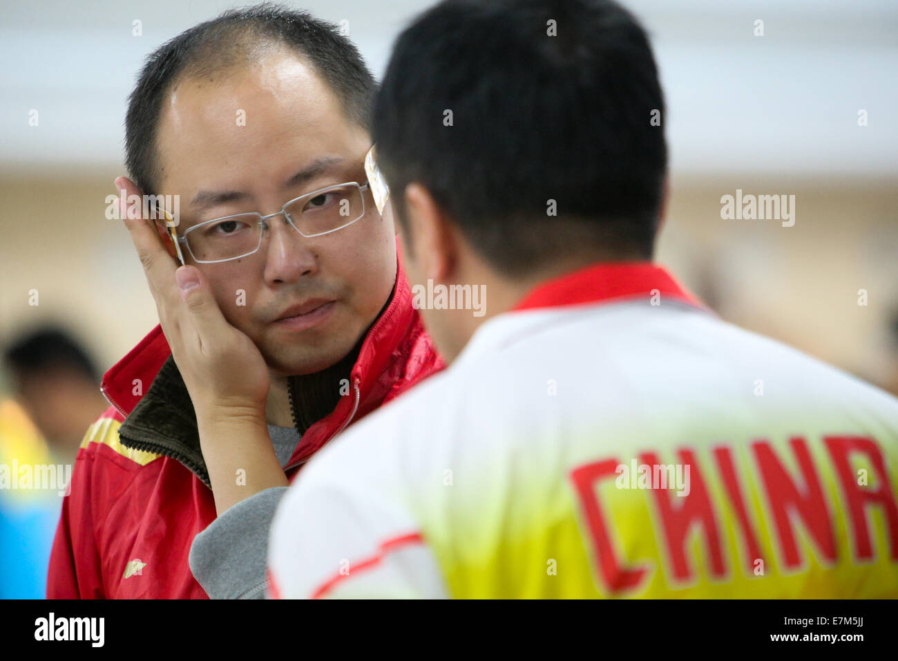 Incheon, South Korea. 21st Sep, 2014. Pu Qifeng of China(L) reacts duirng the men's 10m Pistol team finals of shooting event at the 17th Asian Games in Incheon, South Korea, Sept. 21, 2014. China got the silver medal with 1,743 points. Credit:  Zhang Fan/Xinhua/Alamy Live News Stock Photo